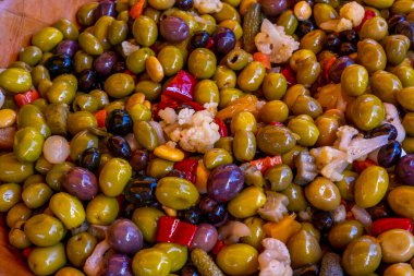 Fransız vilayetindeki haftalık pazarda siyah ve yeşil zeytinleri sebzeyle karıştırdım. Bir kasede marine edilmiş sebzelerin arka planı, yakın plan. Yüksek kalite fotoğraf