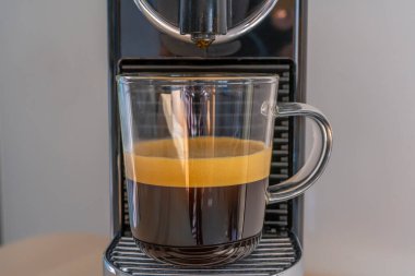 Evde espresso makinesiyle koyu kahve yapıyorum. Ön görünüm.