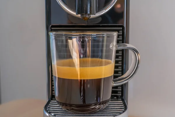 Evde espresso makinesiyle koyu kahve yapıyorum. Ön görünüm.