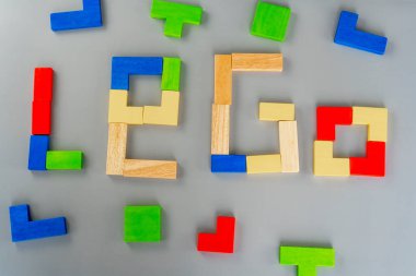 Gri arka planda tahta küp. Masada çok renkli küpler var. Ahşap arka planda geometrik şekiller. Bulmaca konsepti. Yüksek kalite fotoğraf