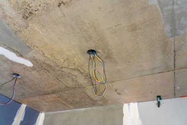 Elektrik delikleri ve tavan ışıkları için kablolar olmadan inşaat halindeki yeni bir dairenin içinde. Yüksek kalite fotoğraf