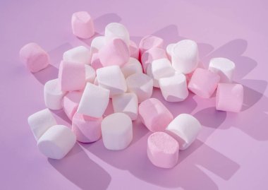 Pembe arka planda renkli mini marşmelovlar. Düz yerde, üst tarafta. Çocuklar tatil yiyecekleri konsepti.