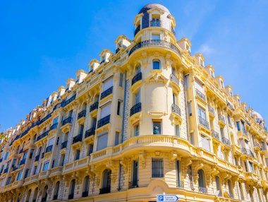 Güzel, FRANCE - 07.05.2021: Ön cephesinde heykel ve mozaikler olan ilginç parlak sarı bina. Fransız şehrindeki eski mimari.. 