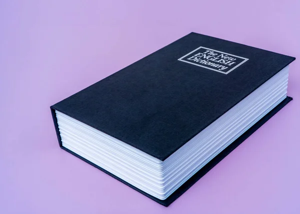 Duży czarny książka angielski słownik na fioletowy odizolowane tło z miejsca na kopiowanie tekstu. — Zdjęcie stockowe
