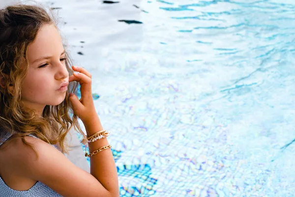 スイミングプールの近くに座って休暇を楽しむ美しい若い女の子. — ストック写真