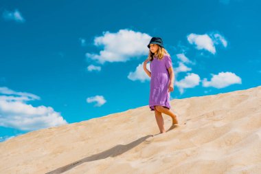 Hava manzaralı fotoğraf, kumlu çölde yalnız bir kız yürüyor.. 