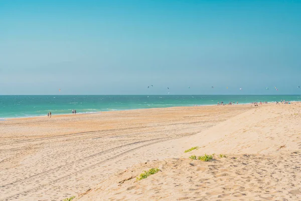 Panoramautsikt över Atlantens havsstrand på sommaren med människor och flygande drakar surfa. — Stockfoto