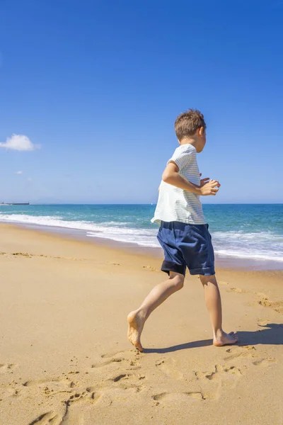 Glad pojke som springer och leker på sommarstranden. Ung tonåring koppla av och ha kul på sommaren semester resor. — Stockfoto