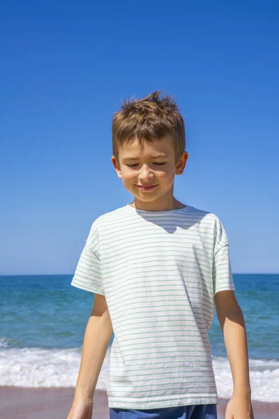 Szczęśliwy chłopak stoi na letniej plaży. Młody nastolatek zrelaksować się i zabawy w letnie wakacje podróży. — Zdjęcie stockowe