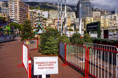 Bu görüntü, Monako 'da kaymak için koruyucu maske ve eldiven takmayı gerektiren buz pateni pistinin girişindeki Coronavirus COVID-19 sosyal mesafe işaretini gösteriyor.