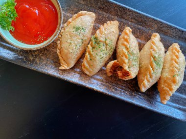 Altın-kahverengi fileto, muhtemelen tavuk şnitzel ya da kızarmış balık, çıtır çıtır, dokulu bir kaplaması var..