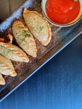 Altın-kahverengi fileto, muhtemelen tavuk şnitzel ya da kızarmış balık, çıtır çıtır, dokulu bir kaplaması var..