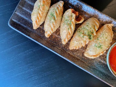 Altın-kahverengi fileto, muhtemelen tavuk şnitzel ya da kızarmış balık, çıtır çıtır, dokulu bir kaplaması var..