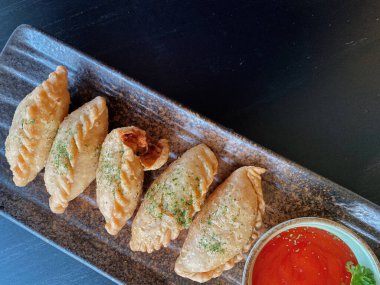 Altın-kahverengi fileto, muhtemelen tavuk şnitzel ya da kızarmış balık, çıtır çıtır, dokulu bir kaplaması var..