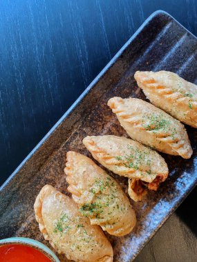 Altın-kahverengi fileto, muhtemelen tavuk şnitzel ya da kızarmış balık, çıtır çıtır, dokulu bir kaplaması var..