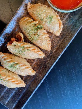 Altın-kahverengi fileto, muhtemelen tavuk şnitzel ya da kızarmış balık, çıtır çıtır, dokulu bir kaplaması var..