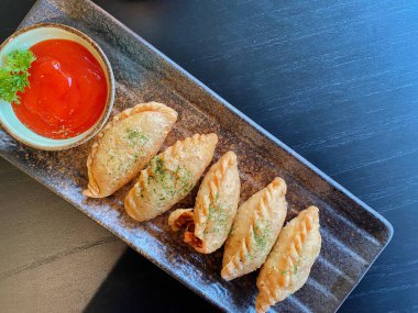 Altın-kahverengi fileto, muhtemelen tavuk şnitzel ya da kızarmış balık, çıtır çıtır, dokulu bir kaplaması var..