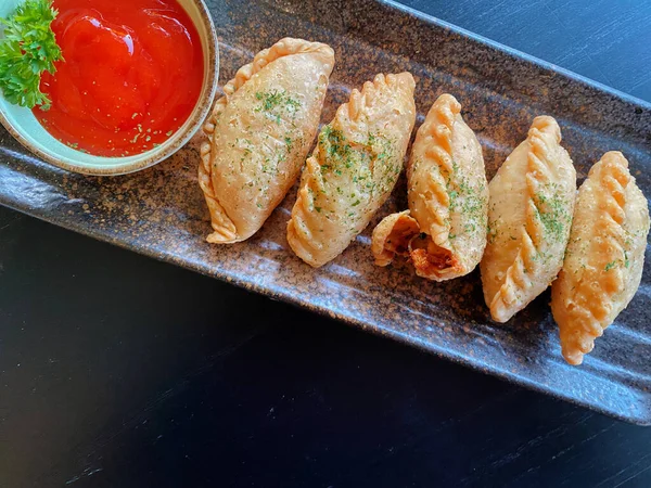 Altın-kahverengi fileto, muhtemelen tavuk şnitzel ya da kızarmış balık, çıtır çıtır, dokulu bir kaplaması var..