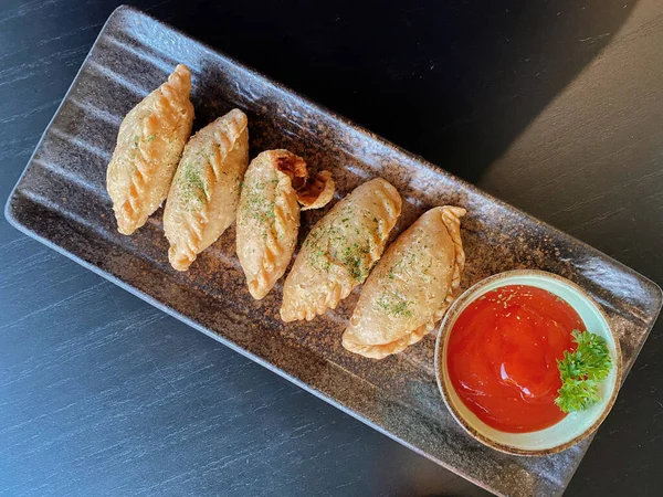 Altın-kahverengi fileto, muhtemelen tavuk şnitzel ya da kızarmış balık, çıtır çıtır, dokulu bir kaplaması var..