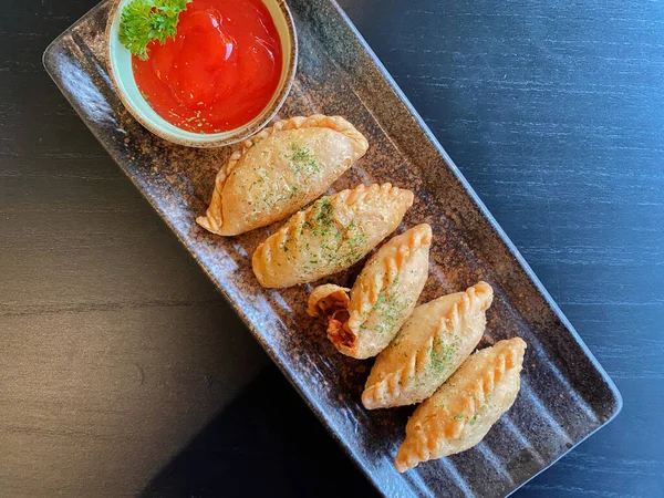 Altın-kahverengi fileto, muhtemelen tavuk şnitzel ya da kızarmış balık, çıtır çıtır, dokulu bir kaplaması var..