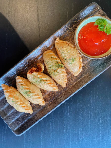 Altın-kahverengi fileto, muhtemelen tavuk şnitzel ya da kızarmış balık, çıtır çıtır, dokulu bir kaplaması var..