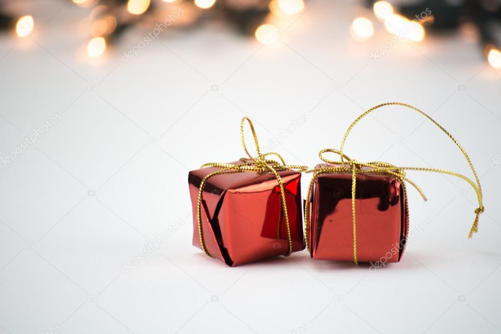 Shining red Christmas ornaments, decoration with gold ribbon on bokeh, blurred background