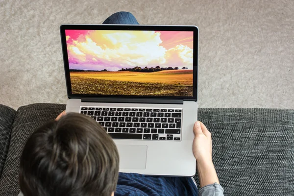 Kadın bir laptop tutar