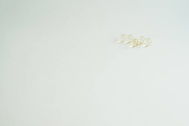 Vitaminli tıbbi kapsüller, sarı küçük yuvarlak kapsüller.