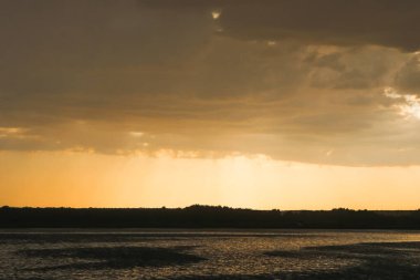 Karanlık yaz günbatımı Bir çayırda, köy gün batımında