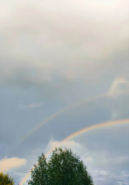 double rainbow in the sky with clouds