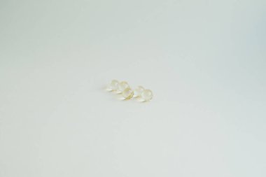 Vitaminli tıbbi kapsüller, sarı küçük yuvarlak kapsüller.