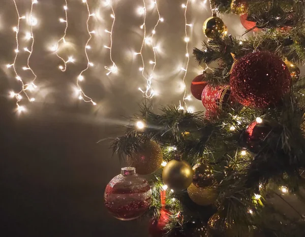 Árvore decorada de Natal no escuro e guirlanda na parede — Fotografia de Stock