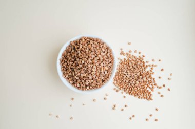 Açık arkaplanda bir fincanda çiğ karabuğday