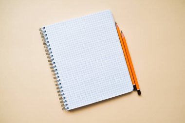 metin için yer, kafeste bir defter ve sarı arka planda kalemler