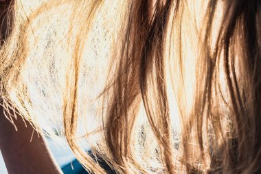 Güneş saçlarının arasından parlıyor.