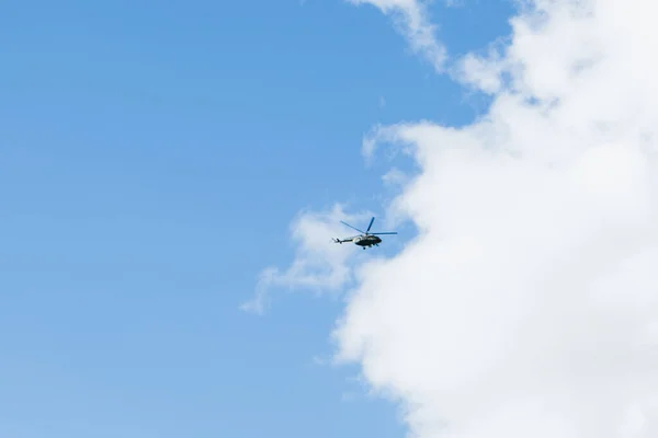 Helicóptero em um fundo de céu azul com nuvens — Fotografia de Stock