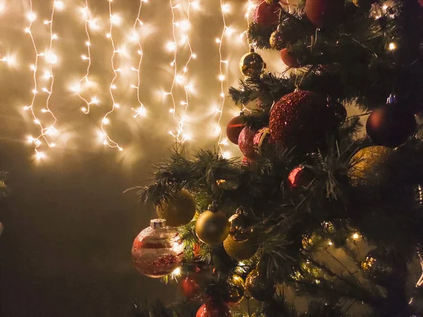 Arbre décoré de Noël dans l'obscurité et guirlande sur le mur — Photo