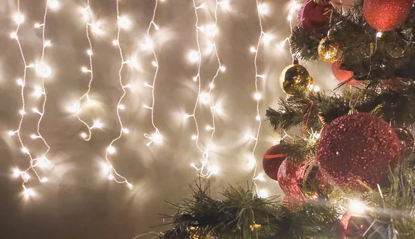 Árvore decorada de Natal no escuro e guirlanda na parede — Fotografia de Stock