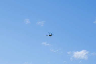 bulutlu mavi gökyüzünün arka planında bir helikopter