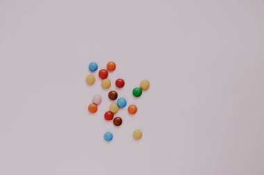 Pembe arka planda çeşitli renkte tatlılar.