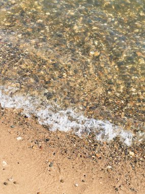 Sahilde sörf, kumlu kumsalda çakıl taşları