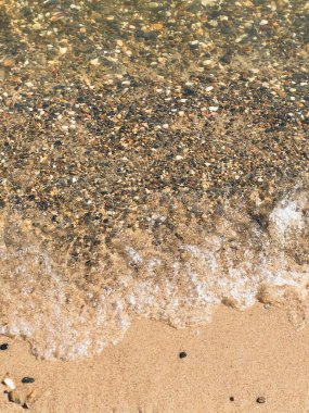 Sahilde sörf, kumlu kumsalda çakıl taşları