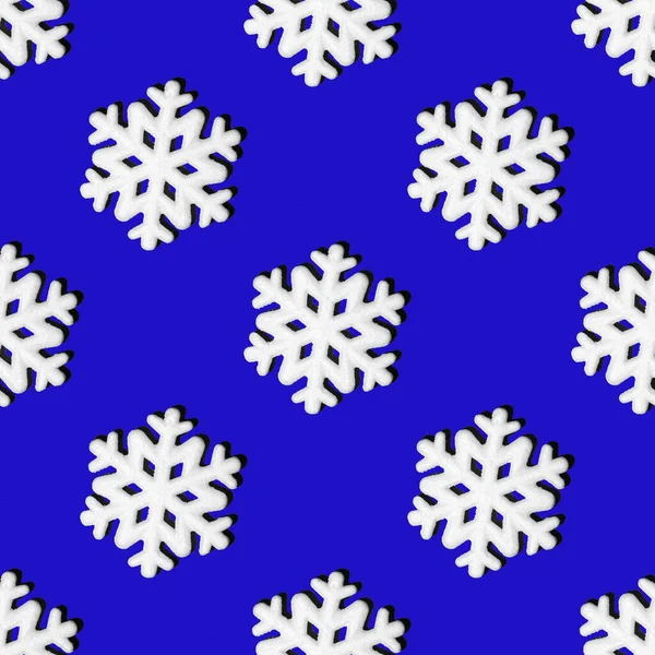 Fondo de Navidad con copos de nieve. Patrón festivo sin costuras de copos de nieve blancos sobre un fondo azul —  Fotos de Stock