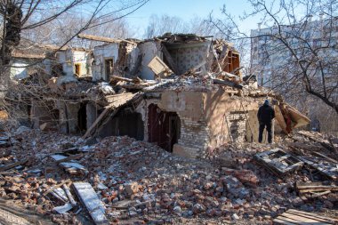 Eski bir binanın yıkılması, bir afetten ya da yaşlılıktan çökmesi, bir adam ayağa kalkıp binaya bakar..