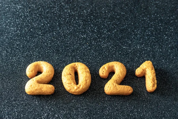 2021年ジンジャーブレッド日付 黒の背景 トップビュー フラットレイアウト コピースペース上の数字2021の形で自家製クッキー クリスマスの装飾食品の背景 — ストック写真