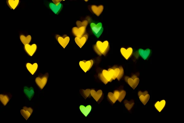 情人节心形背景灯 黄色的金色和绿色的心形的黑色背景彩色灯罩装饰情人节 爱情图片背景 — 图库照片