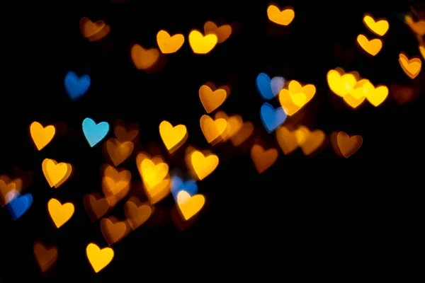 情人节心形背景灯 黄色的金色和蓝色的心形的黑色背景彩色灯罩装饰情人节 爱情图片背景 — 图库照片