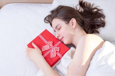Sevgililer günü sabahı. Yatağında kırmızı hediye kutusu olan genç, uyuyan esmer kız. Üst manzara, fotokopi odası. Düğün günü için fotoğraf, Noel, doğum günü