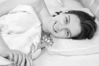 Sevgililer günü sabahı. Güzel esmer kız elinde altın bir gül tutarak yatakta uzanıyor. Evin önünde, fotokopi odasında, siyah beyaz. Düğün, Noel, doğum günü için kullanılabilir.