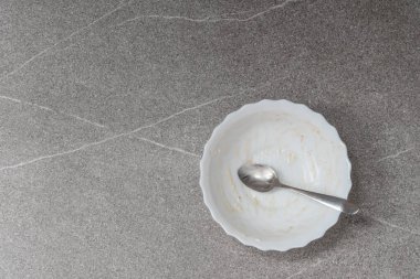 Boş beyaz tabak, kırıntılar ve gri kaşık 2021 son trend arka plan, üst görünüm